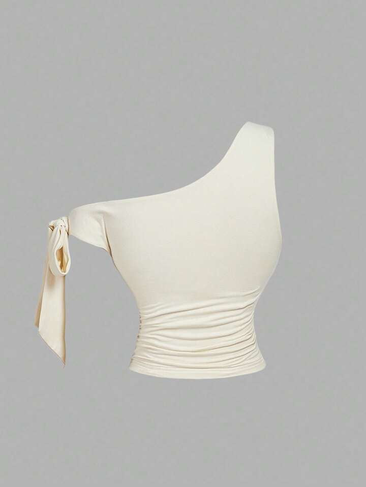 Asymmetrical bowtie metal decor top in nude