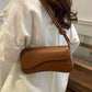 Asymmetrical flap adjustable shoulder bag in brown